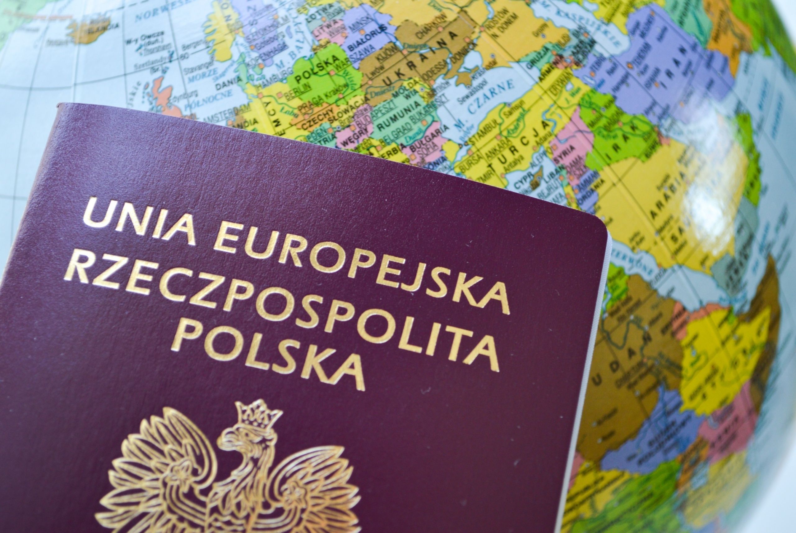 Polski paszport na tle globusa / Shuterstock / fot. TannySolt