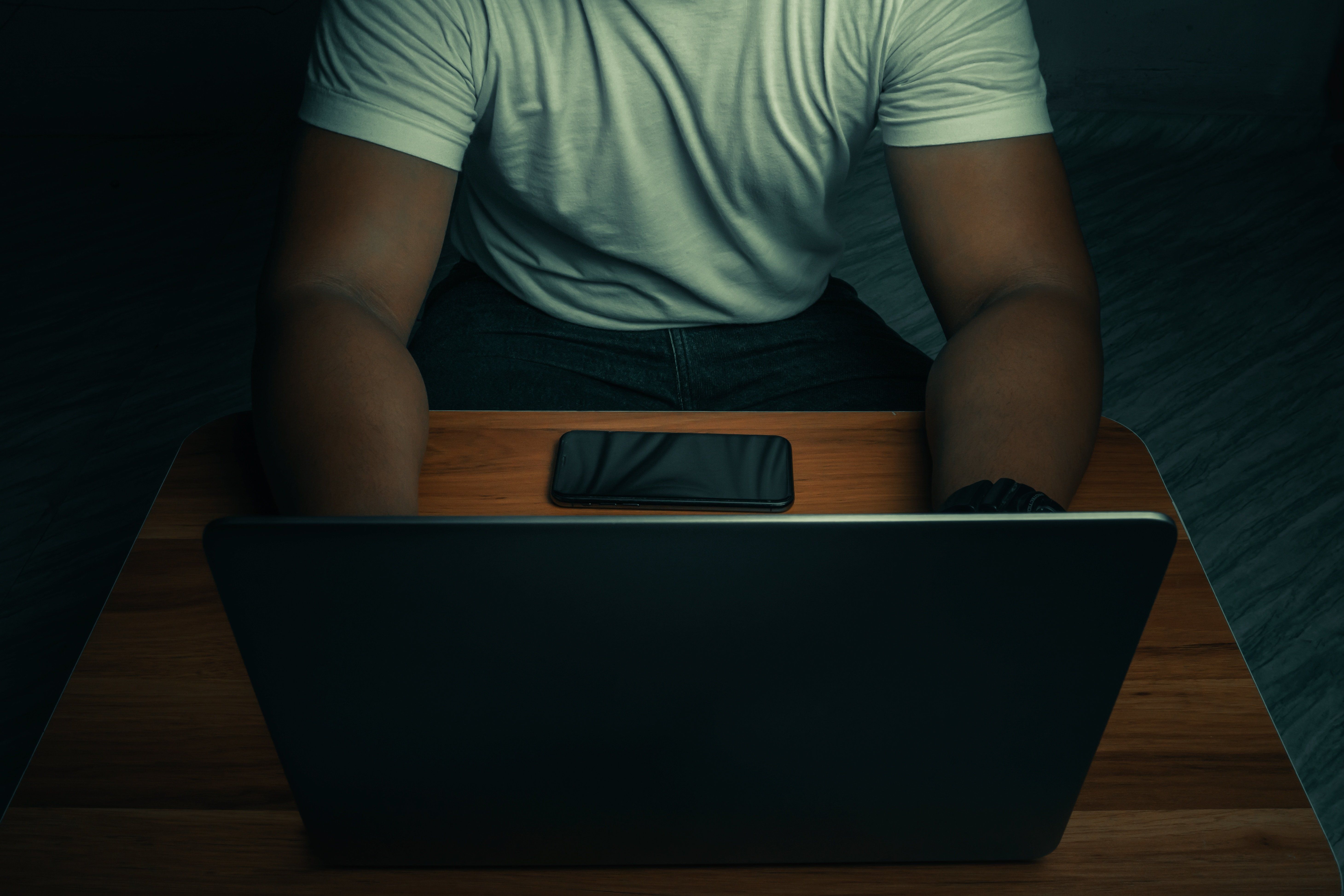 Mężczyzna siedzący przy laptopie.