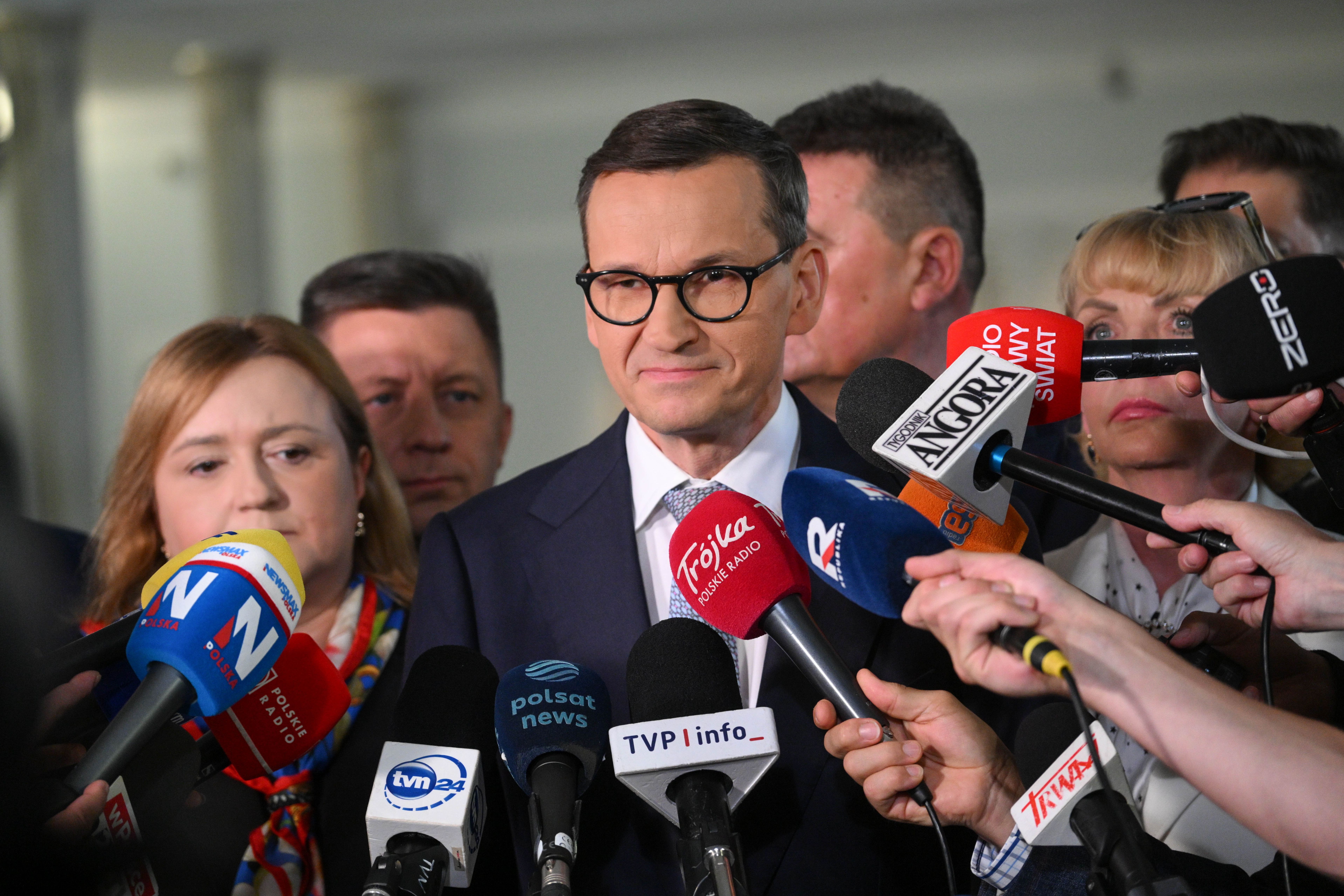 Mateusz Morawiecki odpowiadający na pytania dziennikarzy, w tle mikrofony radiowe