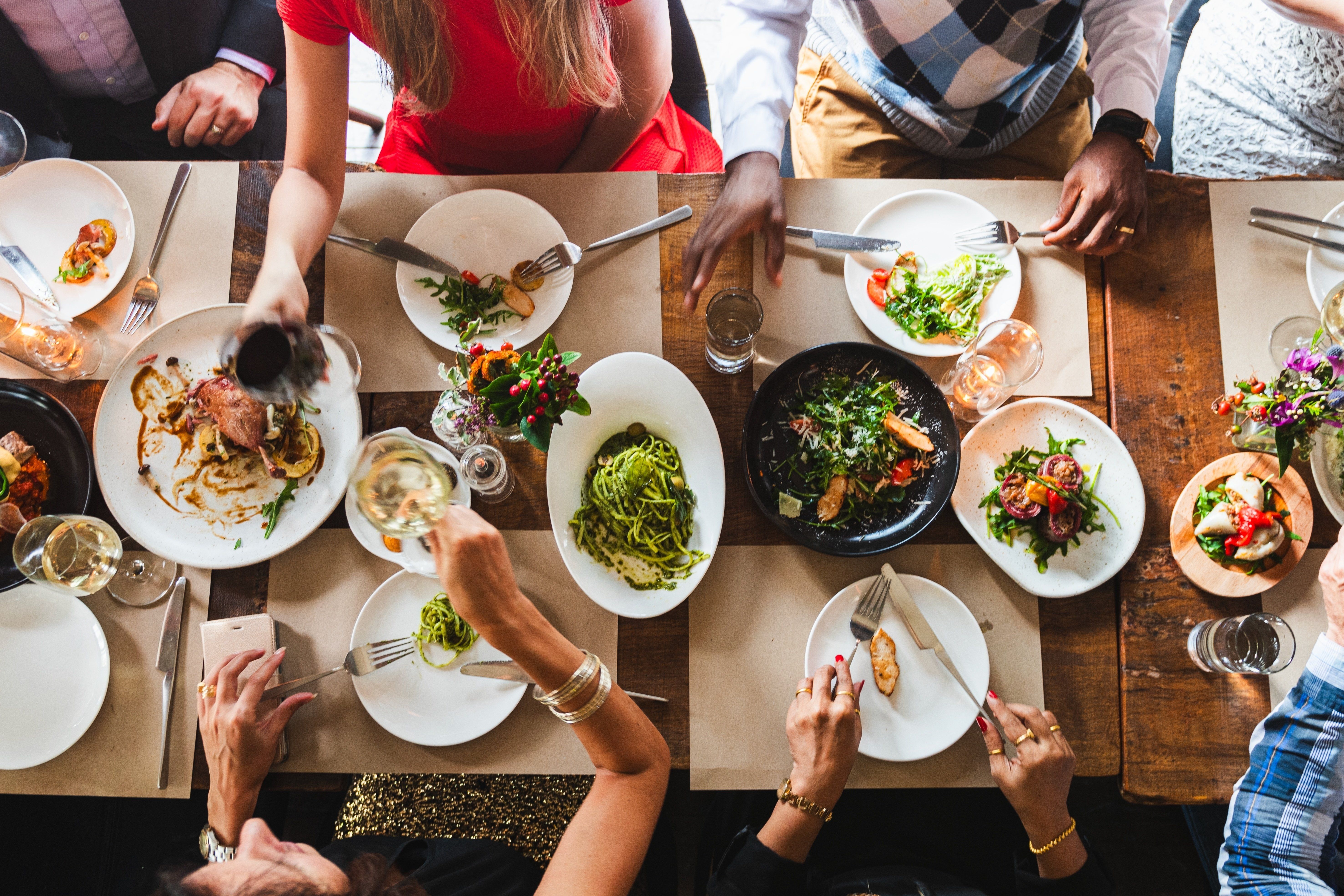 Top,View,Of,Diverse,Group,Dining,Together,,Sharing,Food,,Enjoying
