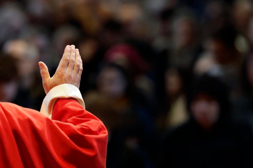 Saint-jacques,Collegiate,Church.,A,Priest,In,Red,Vestments,Gives,A