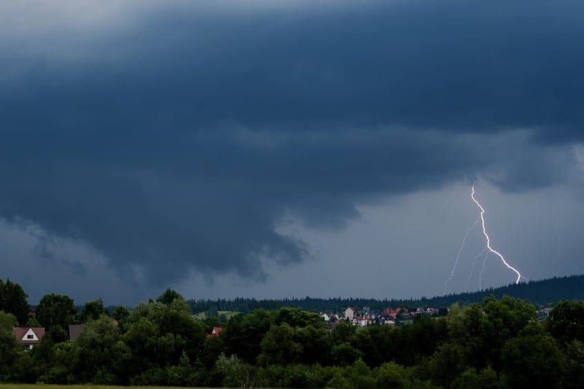 Lightning,Bolt,Striking,Near,Town,Silhouette,And,Forest,During,Summer
