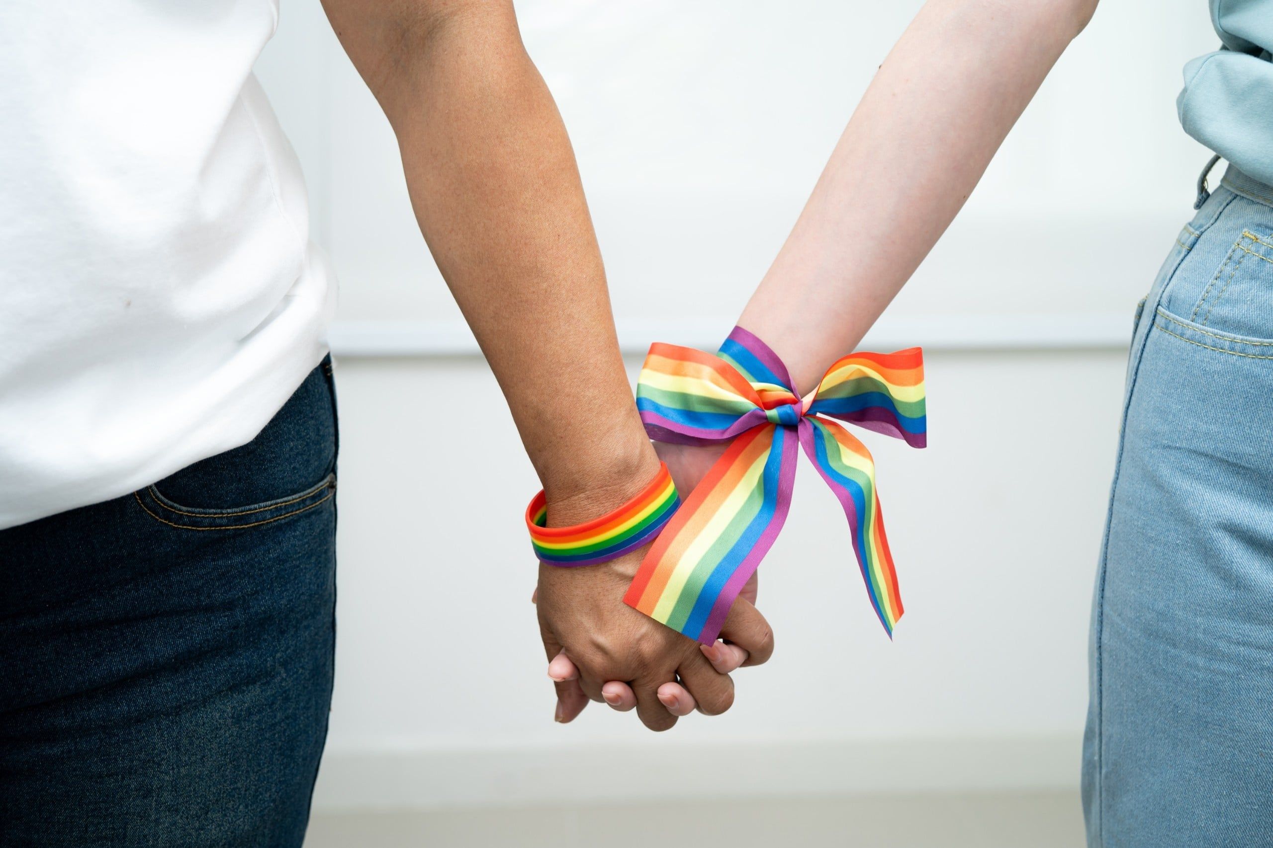 Asian,Lgbt,Couple,Woman,Holding,Hand,Wearing,Rainbow,Wristband.