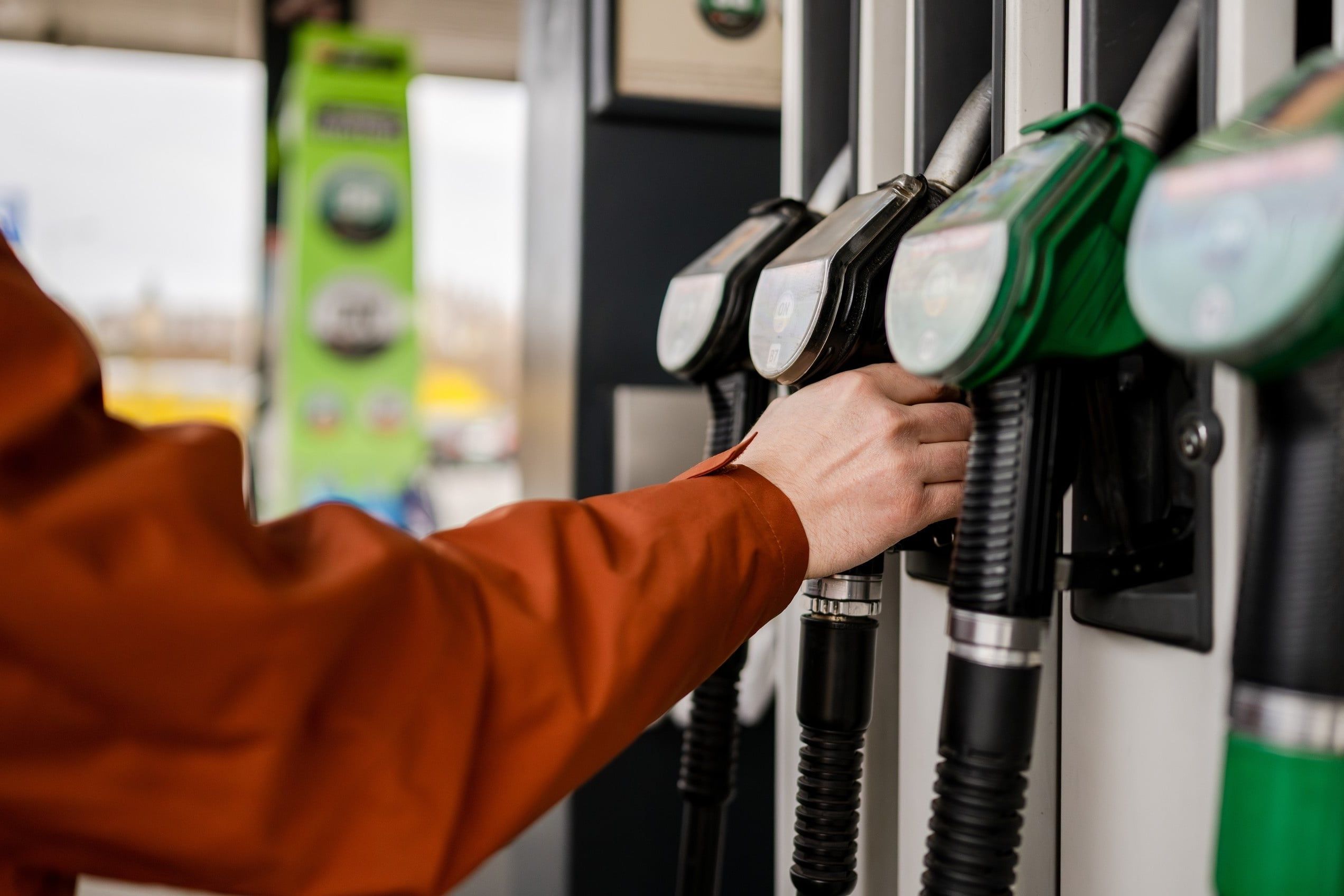 Man,Grabbing,A,Fuel,Pump,At,A,Gas,Station,Refueling