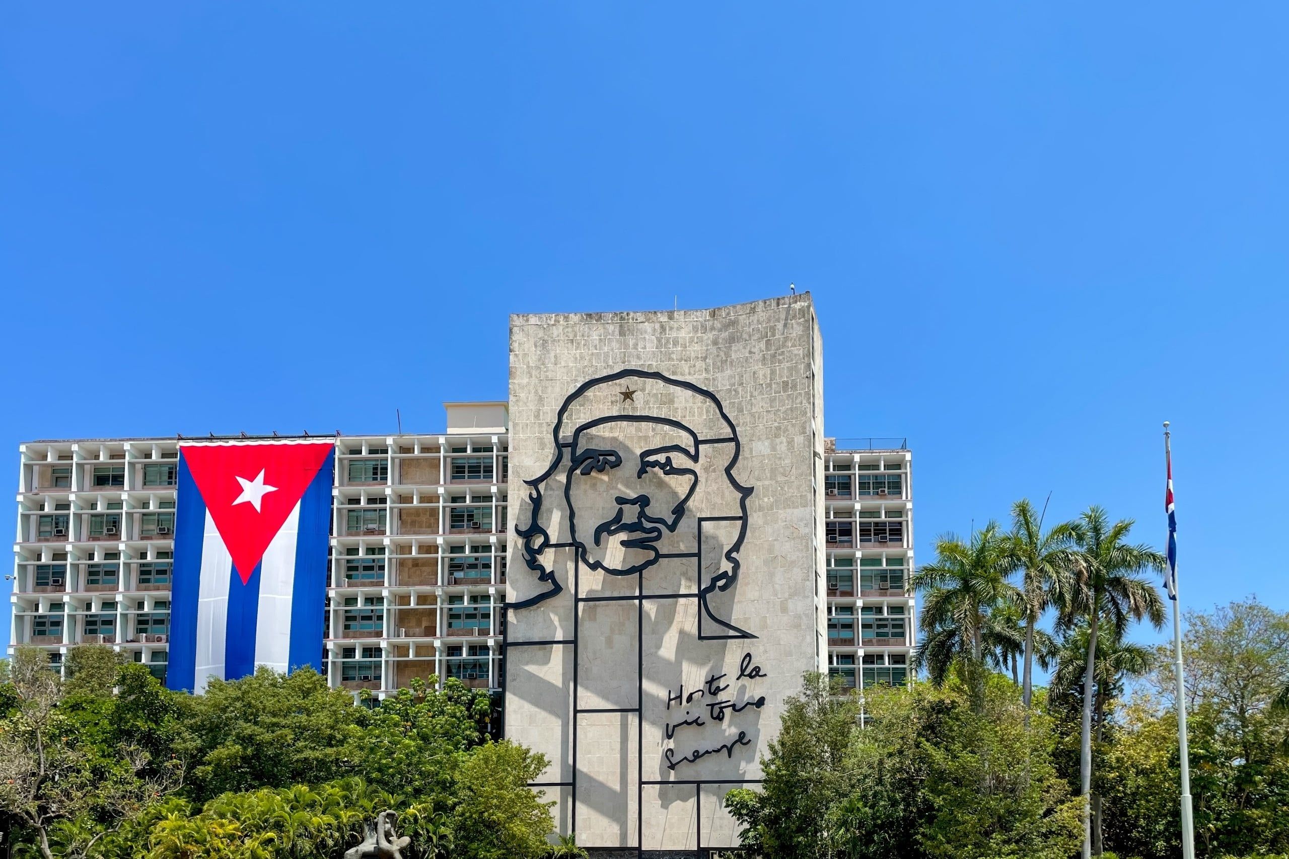 Che,Guevara,Mural,And,A,Cuban,Flag,On,A,Government