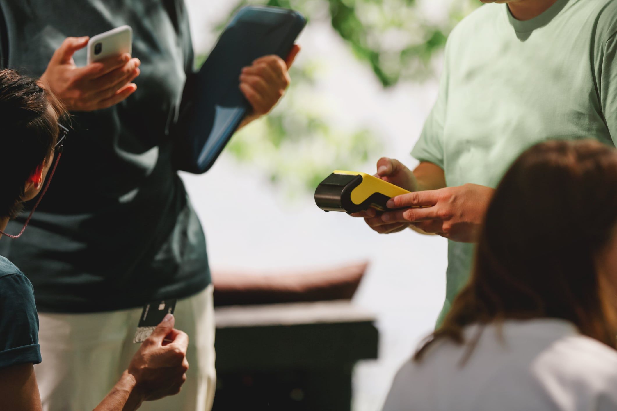 Man's Hand Holding Yellow Paying Terminal And Ready Contactless Payment With Credit Card Or Smartphone