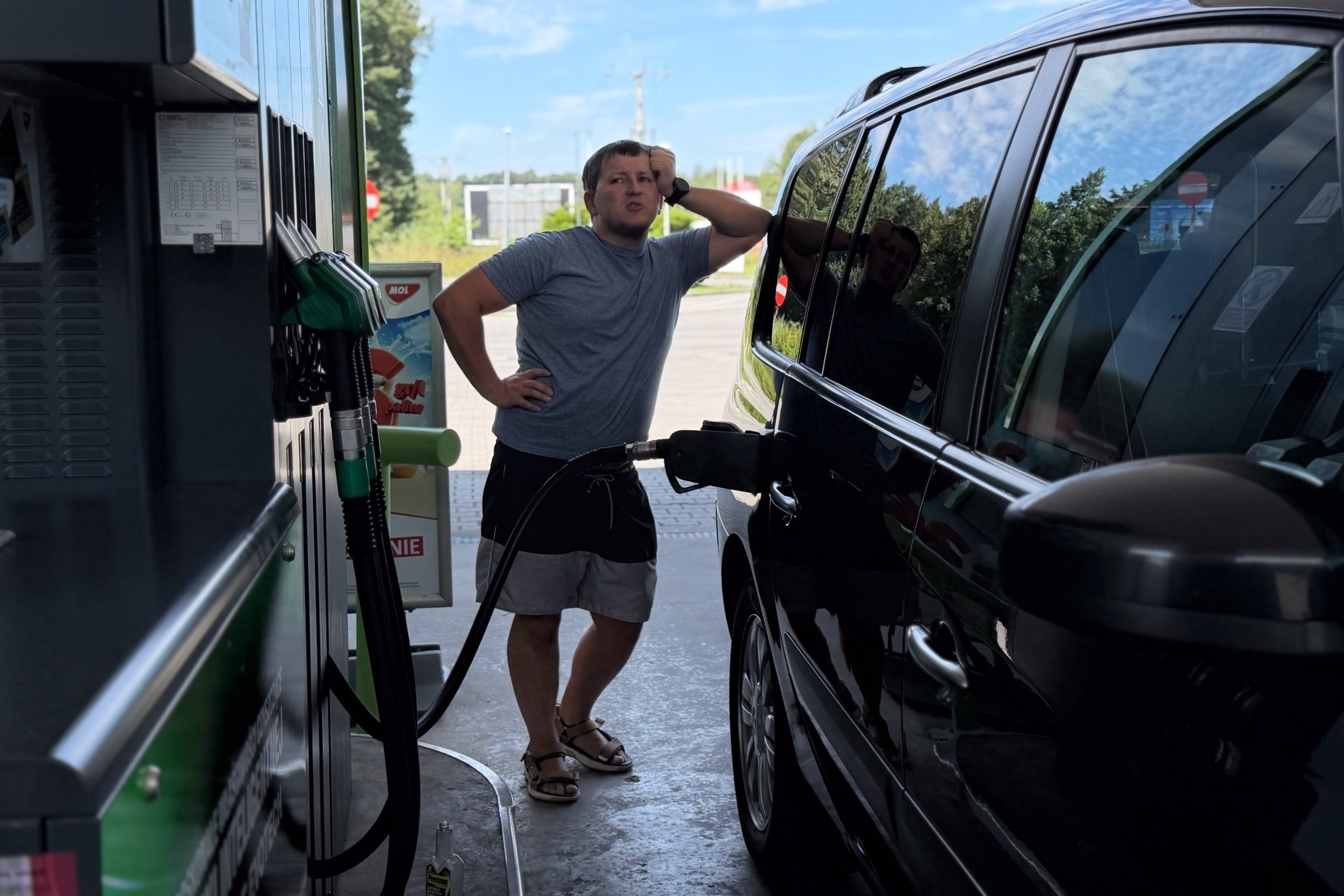 Man,Standing,By,A,Black,Car,While,Refueling,At,A