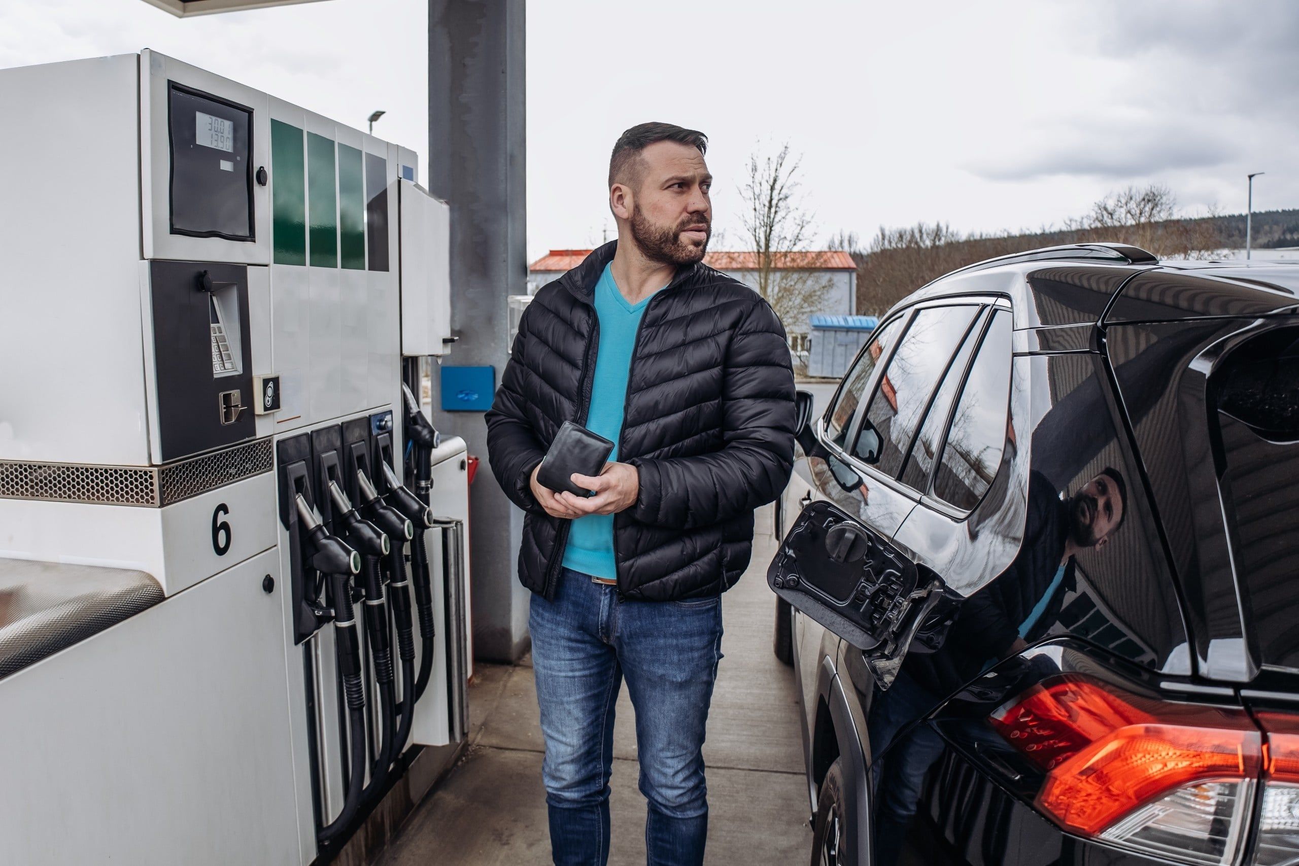 Mężczyzna tankujący auto na stacji benzynowej