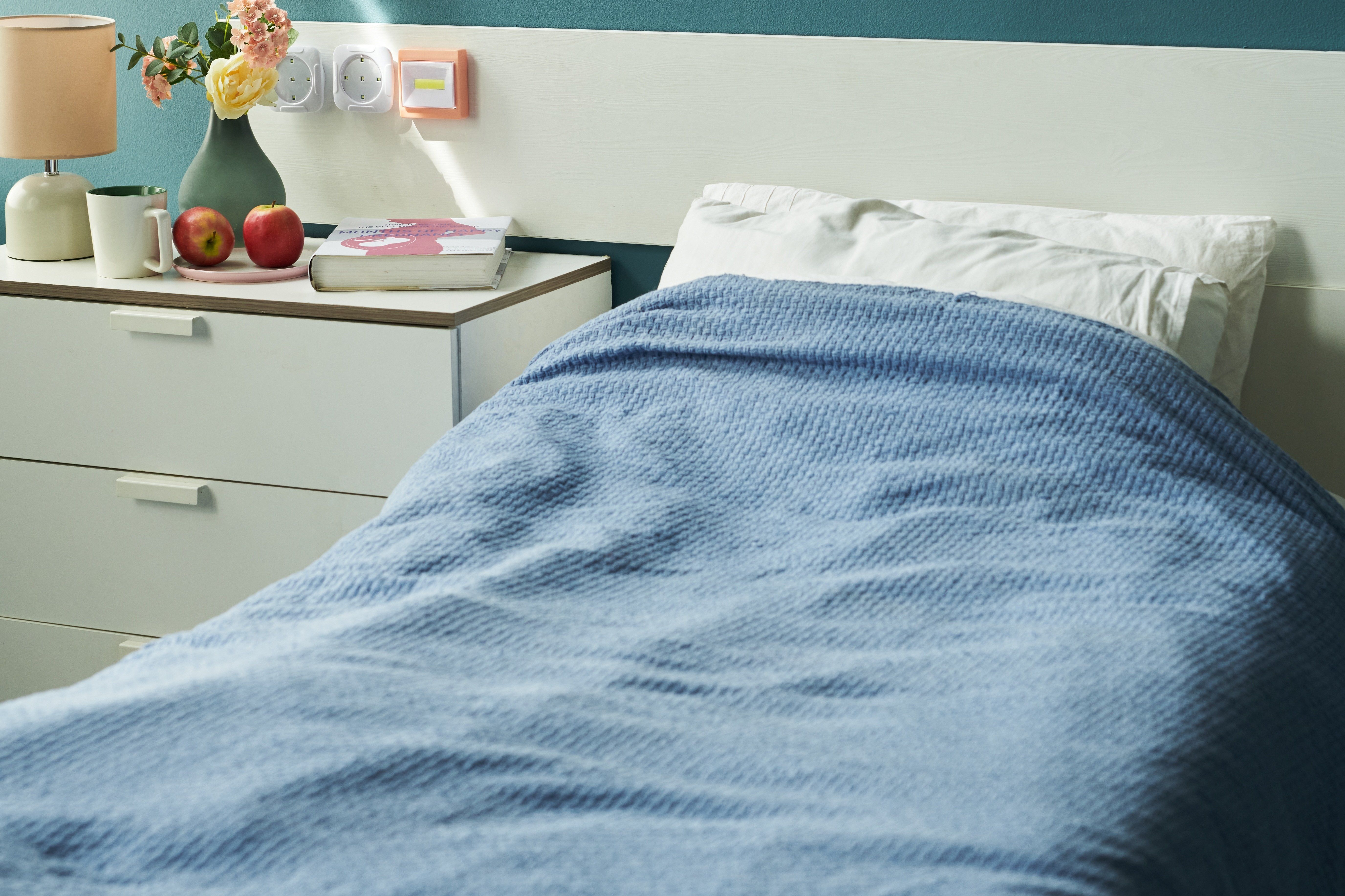 Hospital,Bed,With,Blue,Blanket,Standing,In,Medical,Room,,Bedside