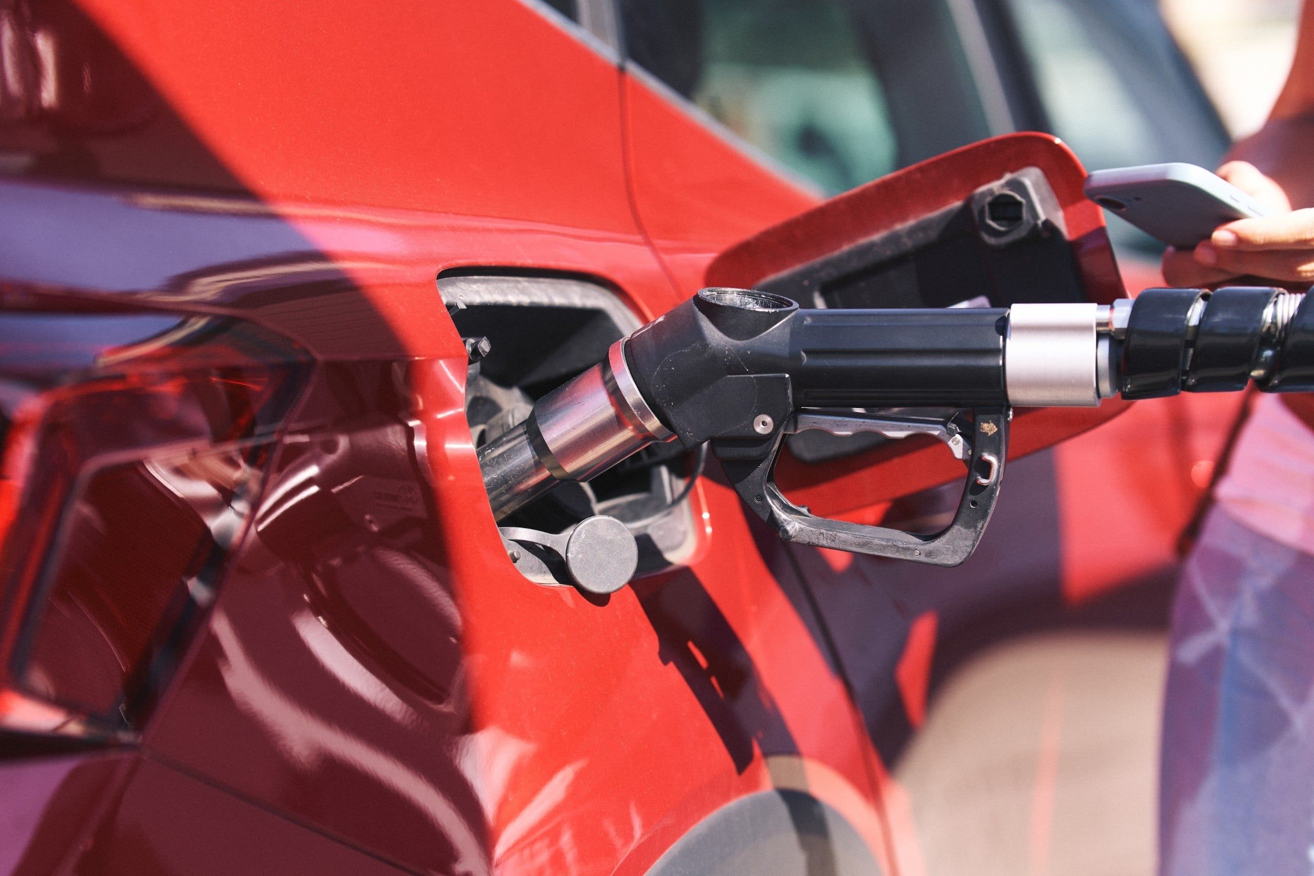 Person,Filling,Up,A,Red,Car,With,Gasoline,,Showing,The