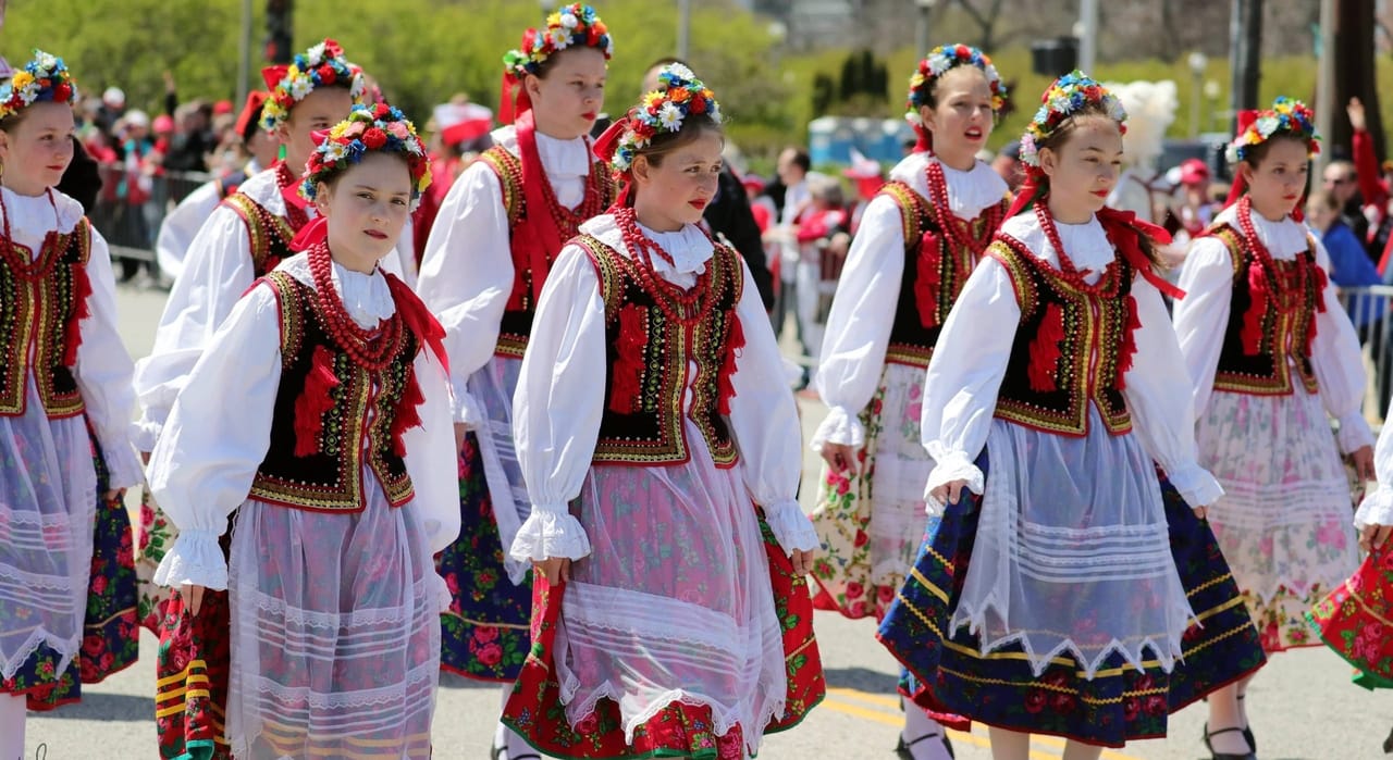 dziewczęta w tradycyjnych polskich strojach ludowych z wiankami kwiatów maszerujące podczas parady Polonii w Chicago