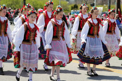 dziewczęta w tradycyjnych polskich strojach ludowych z wiankami kwiatów maszerujące podczas parady Polonii w Chicago