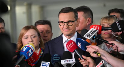 Mateusz Morawiecki odpowiadający na pytania dziennikarzy, w tle mikrofony radiowe