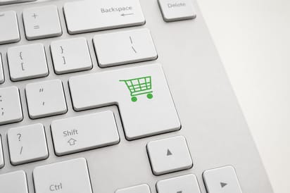 Klawisz z ikoną koszyka zakupowego symbolizujący zakupy online i promocje w internecie