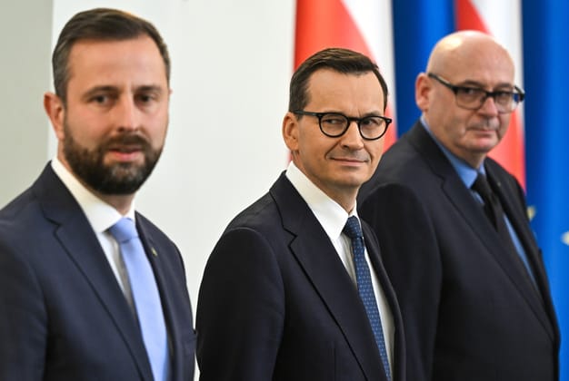 Władysław Kosiniak-Kamysz, Mateusz Morawiecki i Piotr Zgorzelski na tle flag Polski i Unii Europejskiej