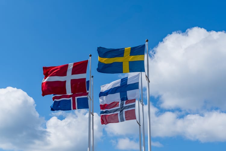 Scandinavian,Countries,Flags,Waving,On,Metal,Poles,Against,Blue,Sky.