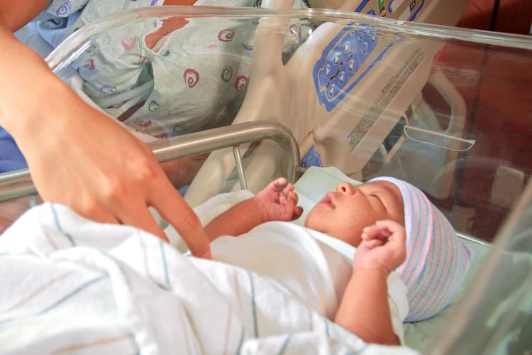 Close,Up,Of,Loving,Mother,With,Newborn,Baby,Boy,Lying